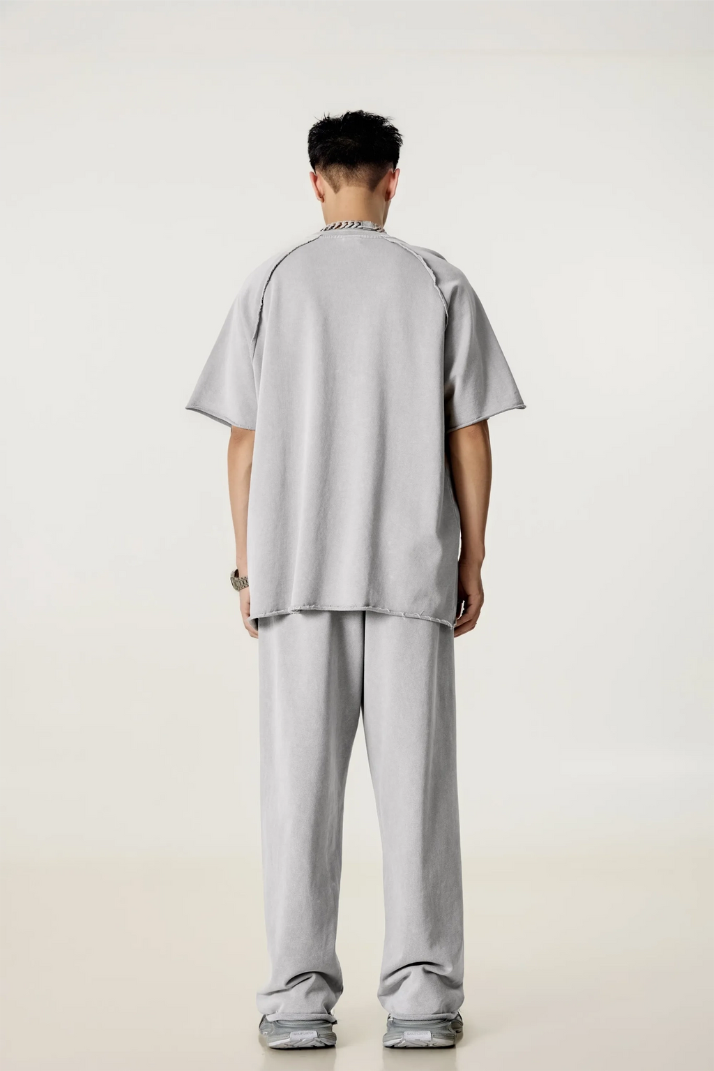 Person wearing a gray outfit on a plain background