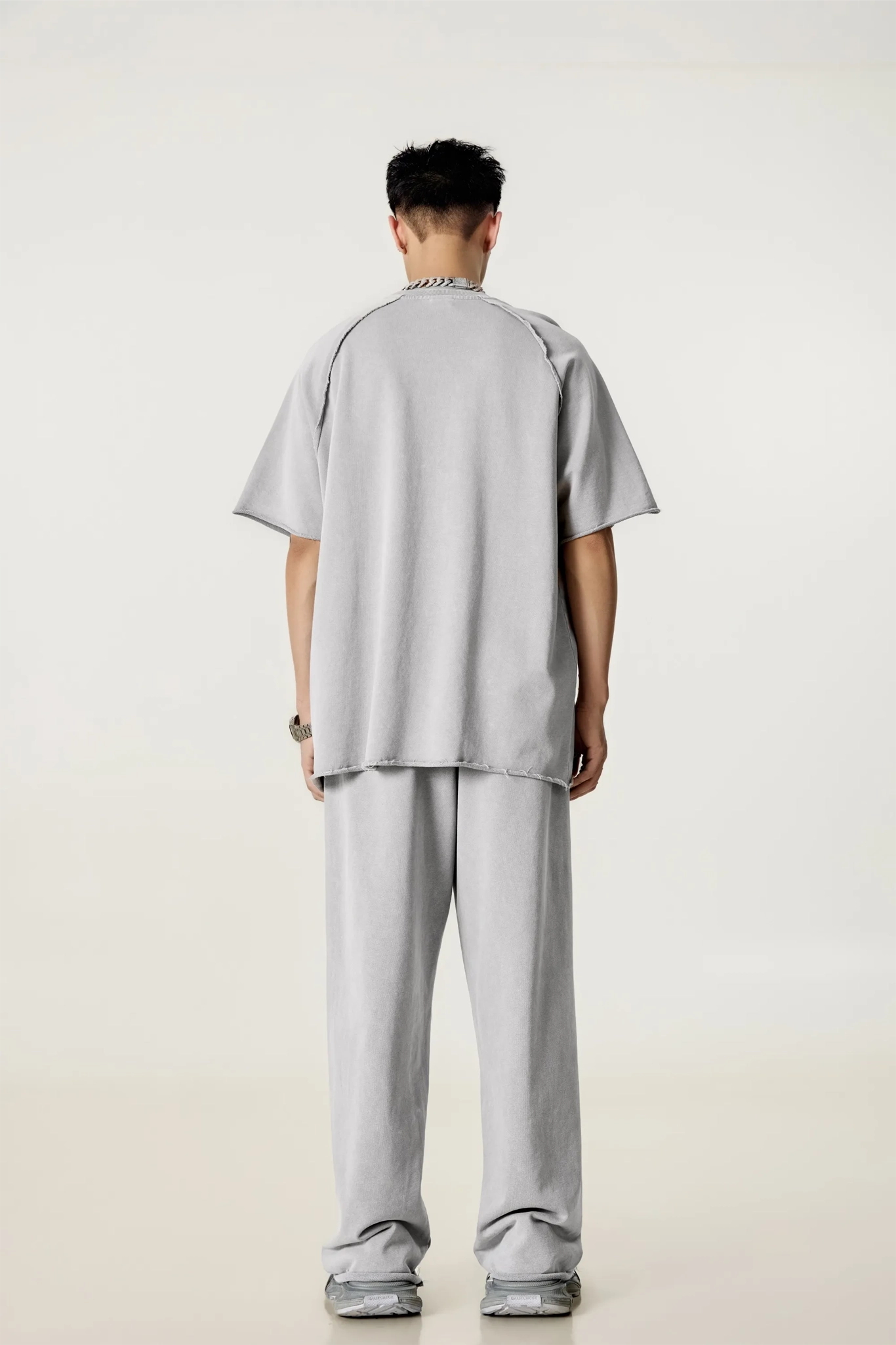 Person wearing a gray outfit on a plain background