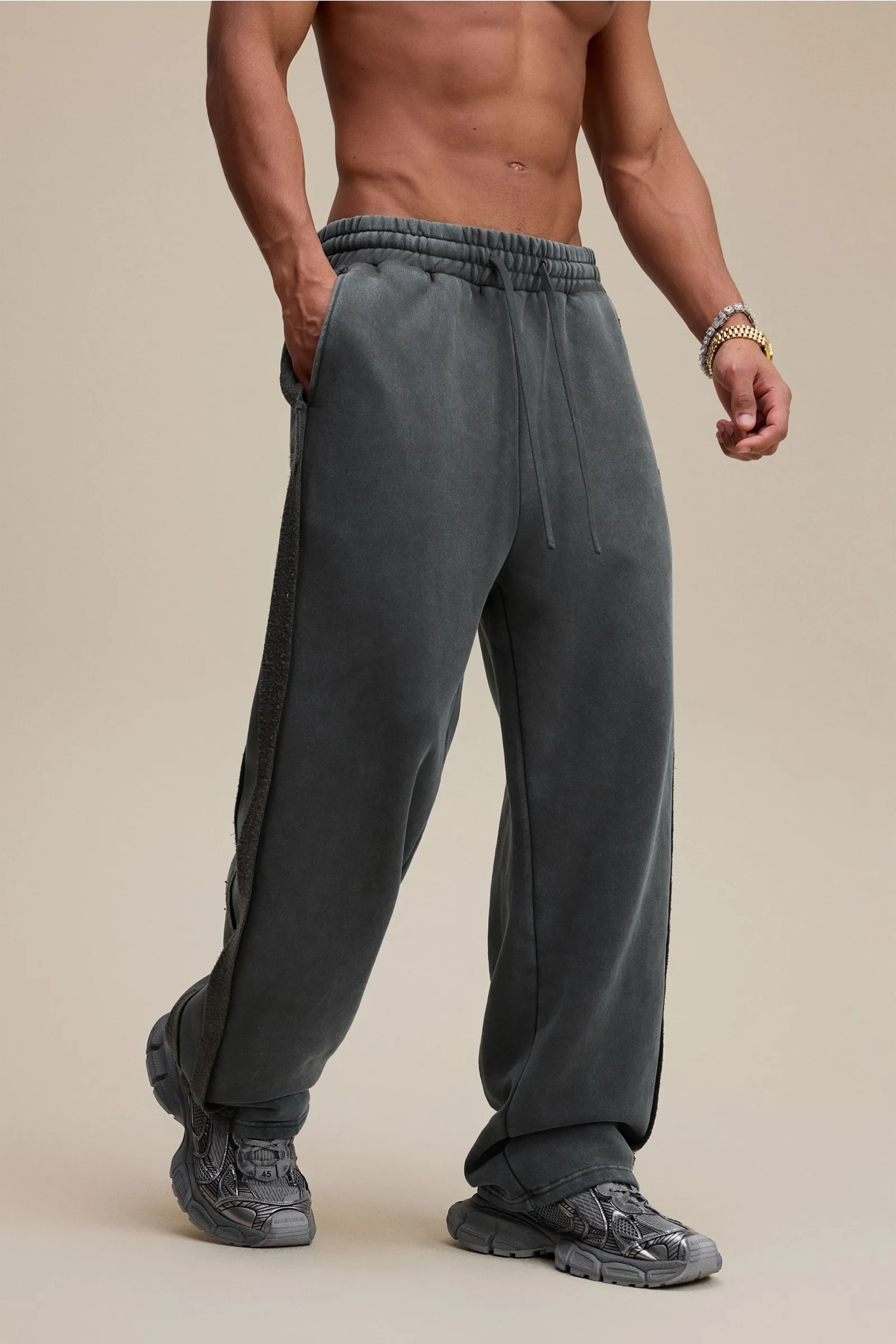 Man wearing gray sweatpants on a beige background