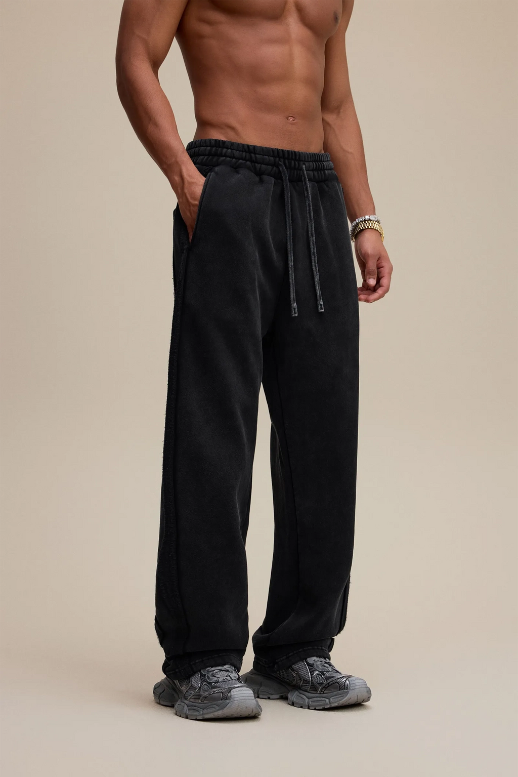 Man wearing black pants on a beige background