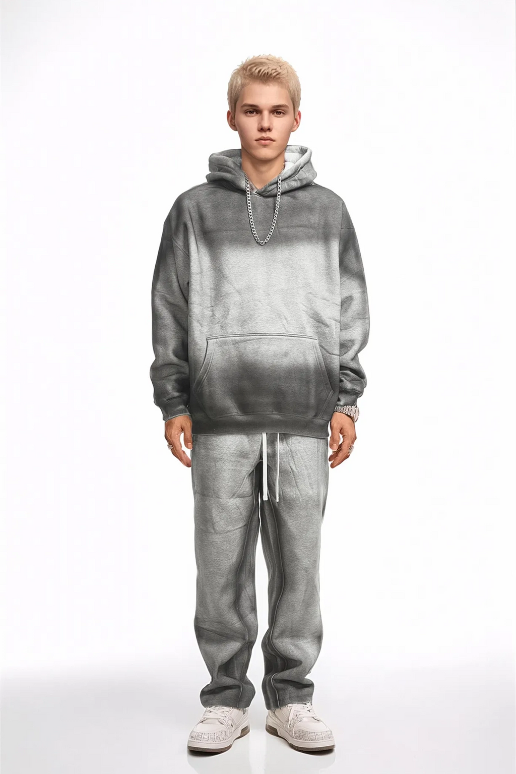Person wearing a gray gradient hoodie and pants on a white background