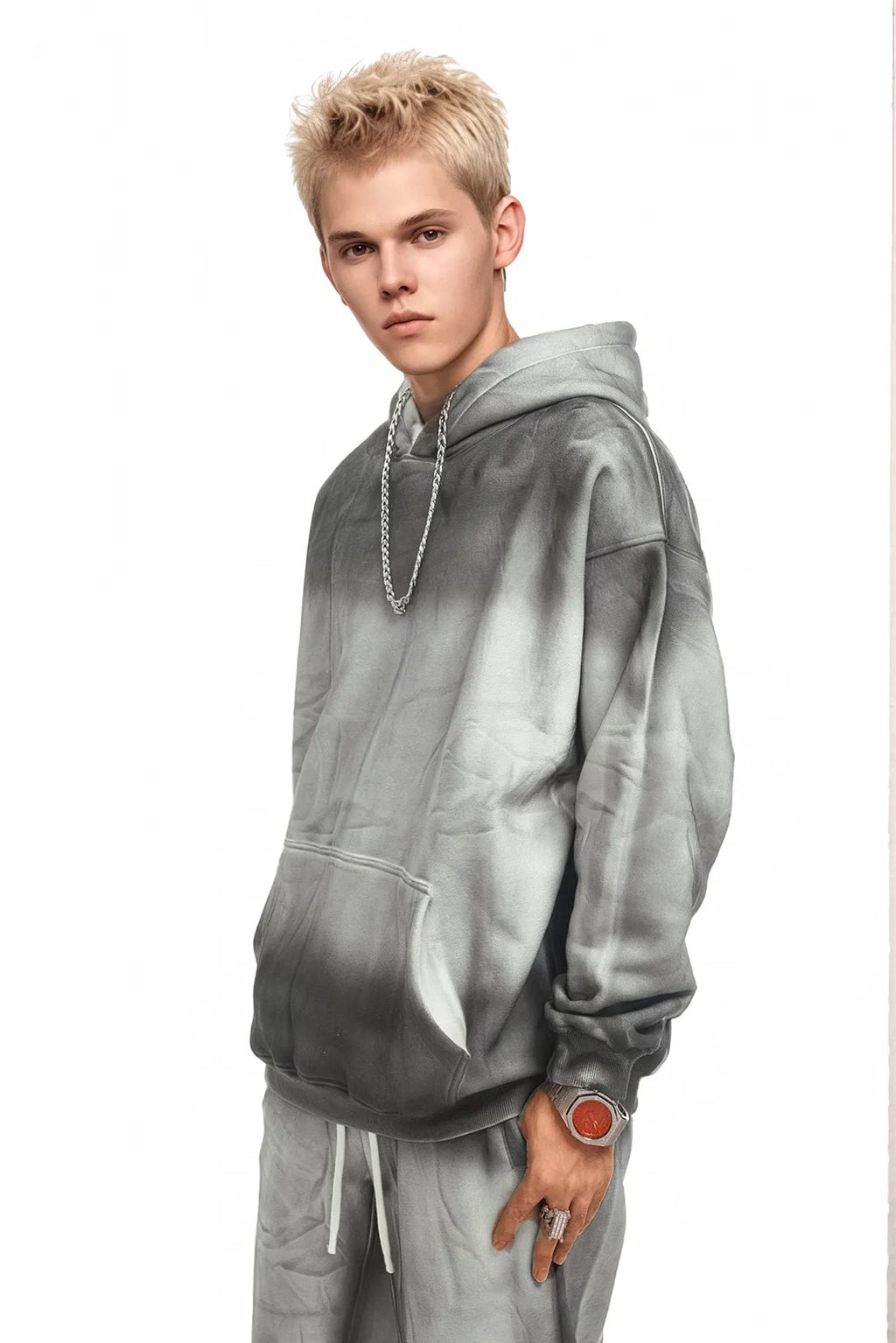 Person wearing a gray hoodie and pants on a white background