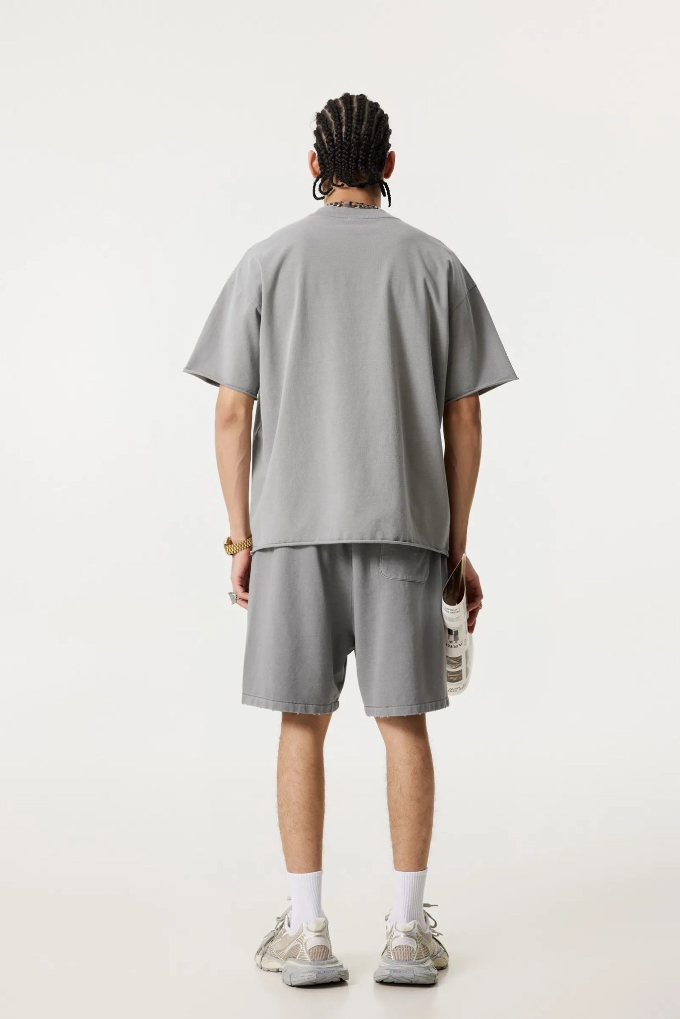 Person wearing a gray t-shirt and shorts set on a white background