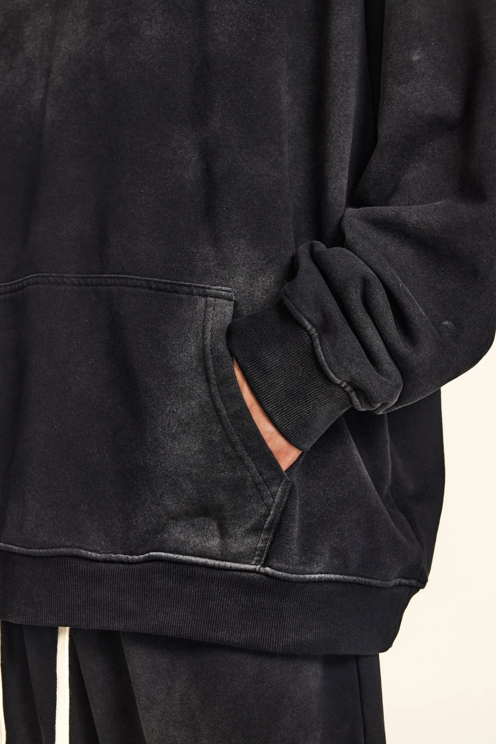 Black hoodie with a pocket on a beige background