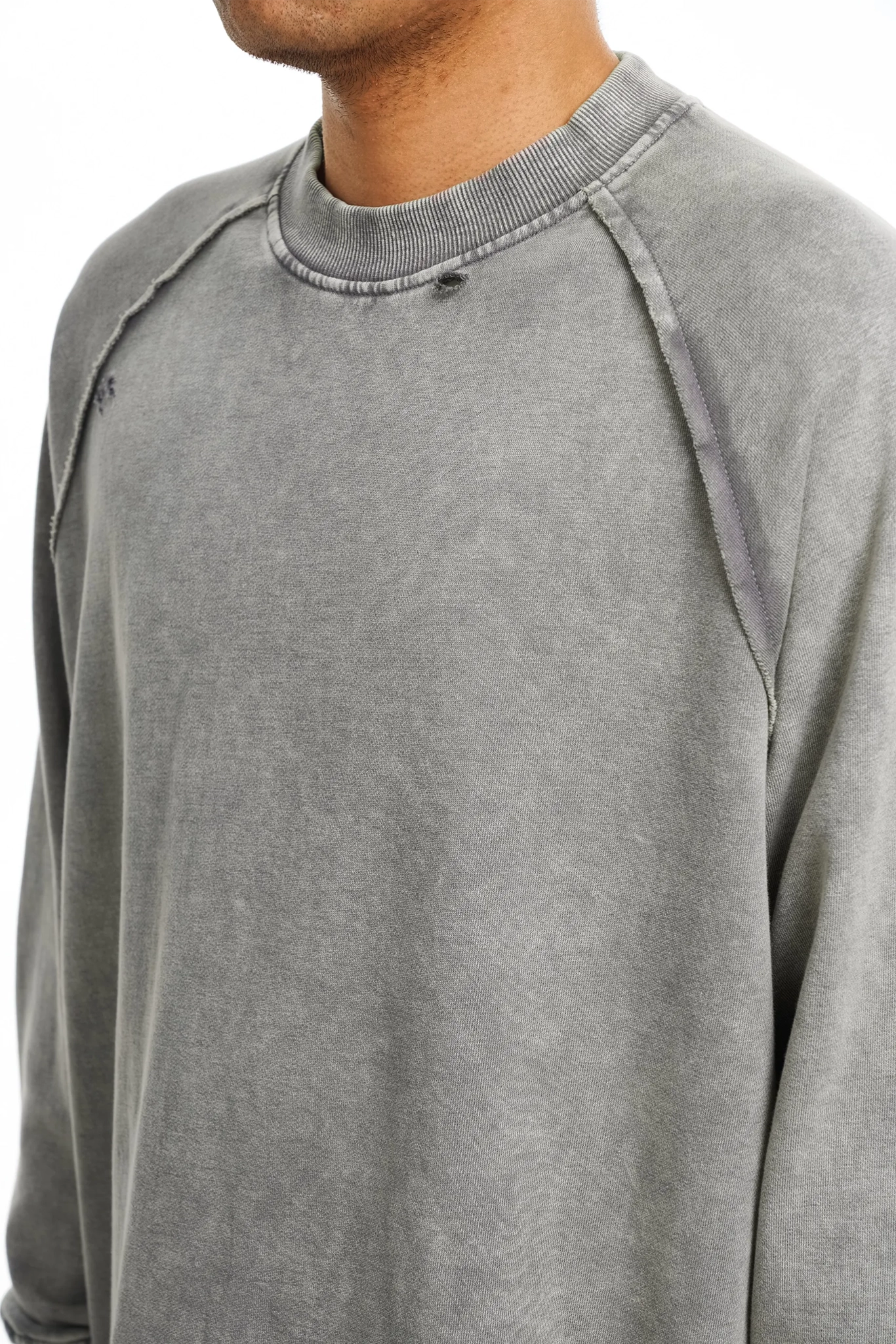 Close-up of a gray long-sleeve shirt with raglan sleeves.