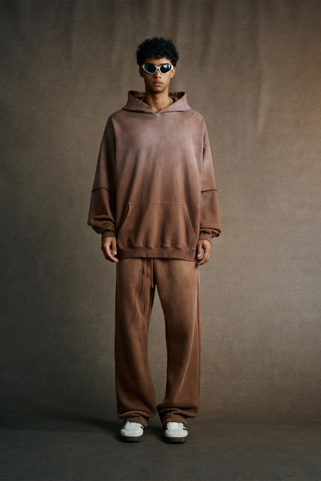 Person wearing a brown tracksuit against a plain background