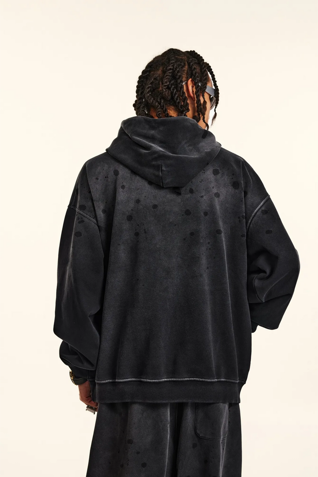 Person wearing a black hoodie with a plain background