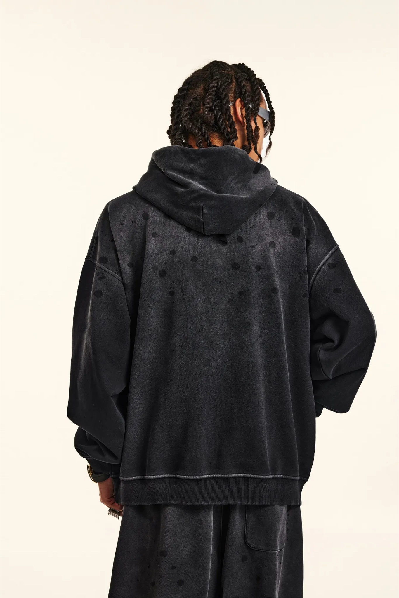 Person wearing a black hoodie with a plain background