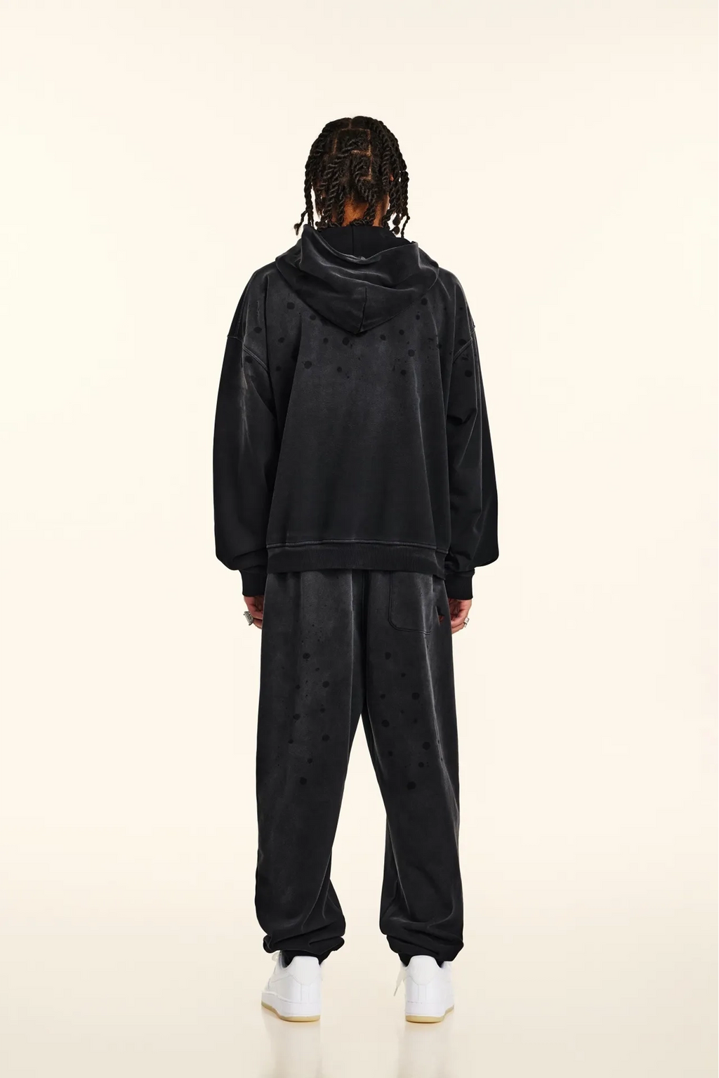 Person wearing a black tracksuit on a white background