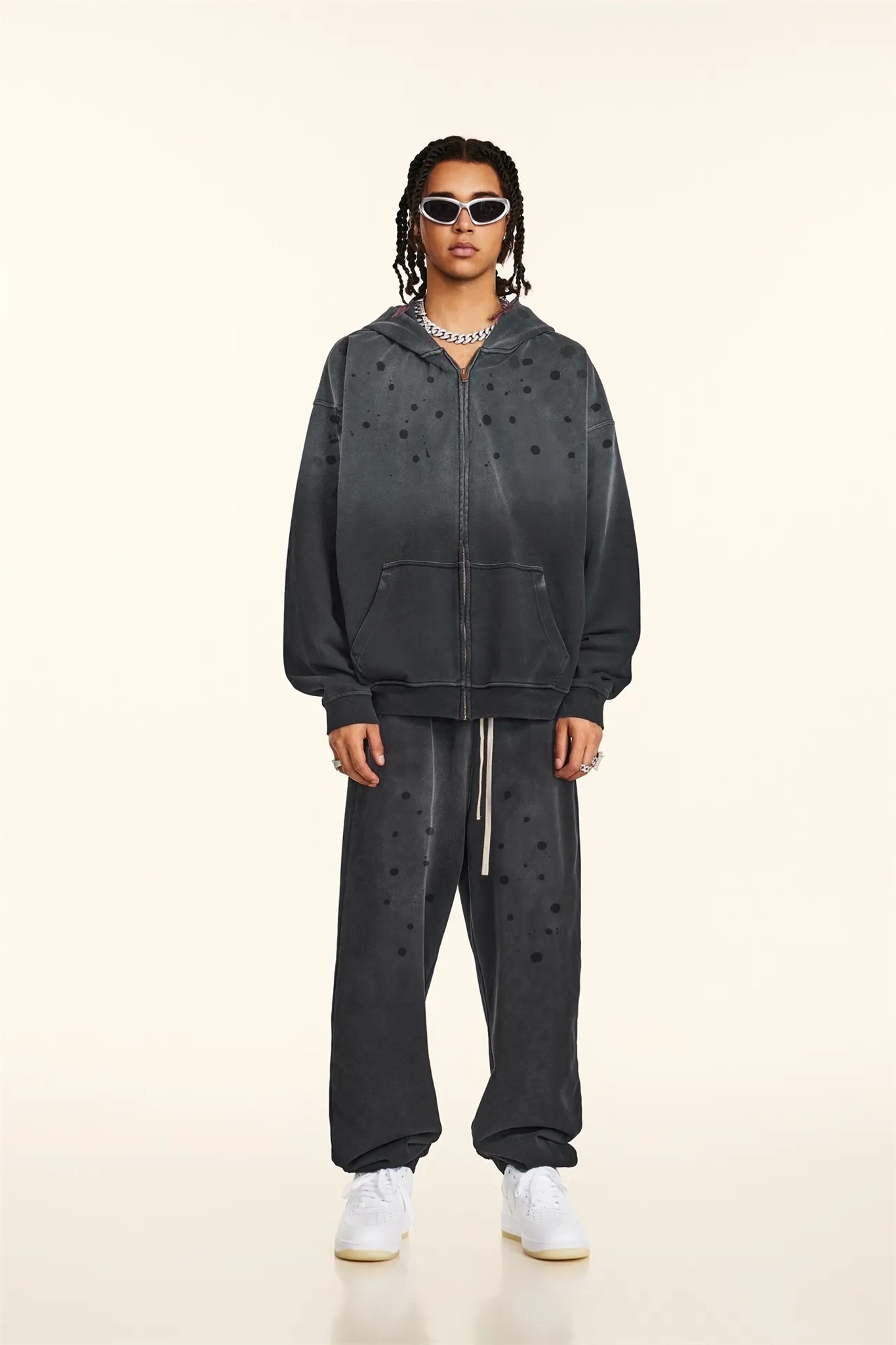 Person wearing a black tracksuit with star patterns on a beige background