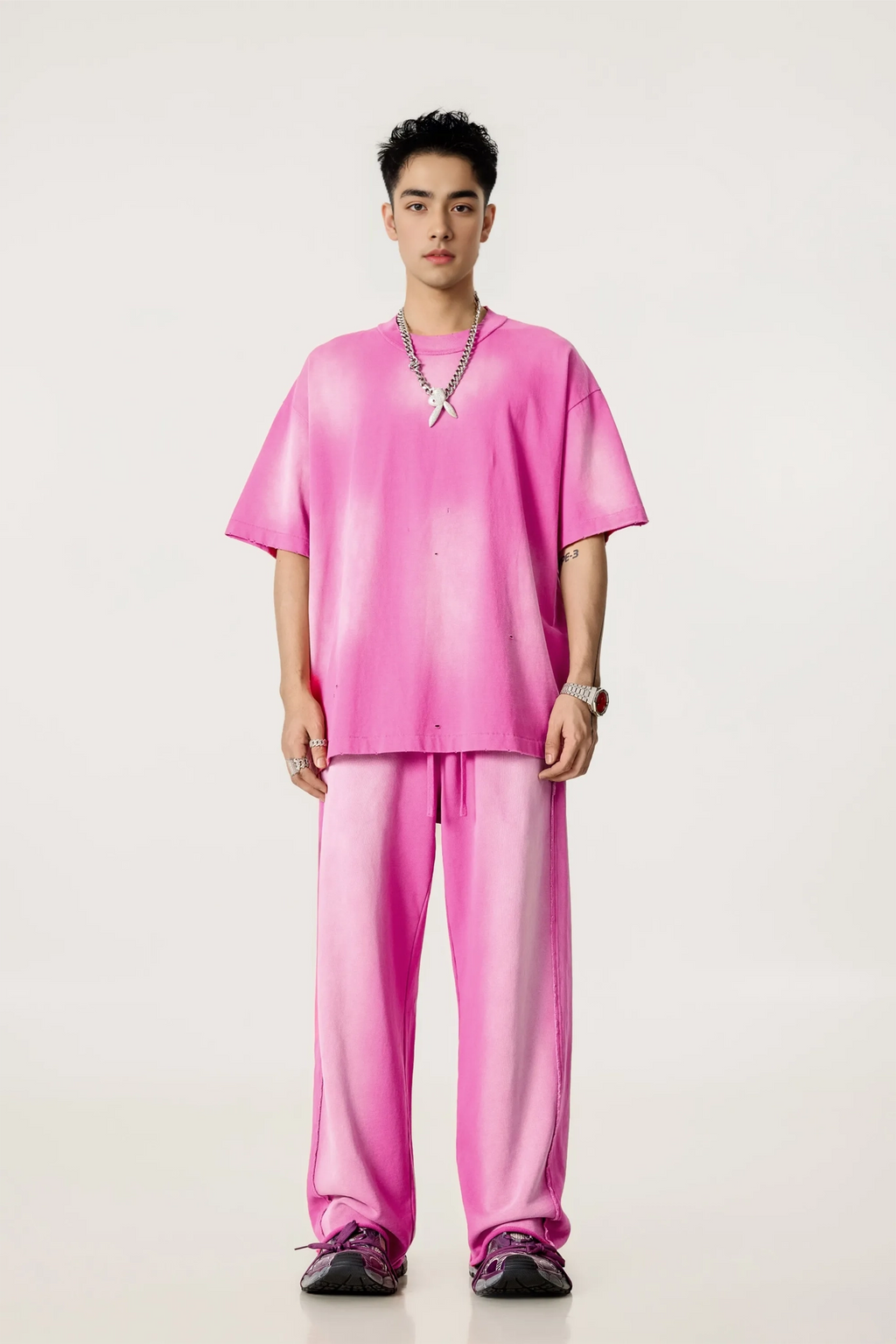 Person wearing a bright pink outfit on a white background