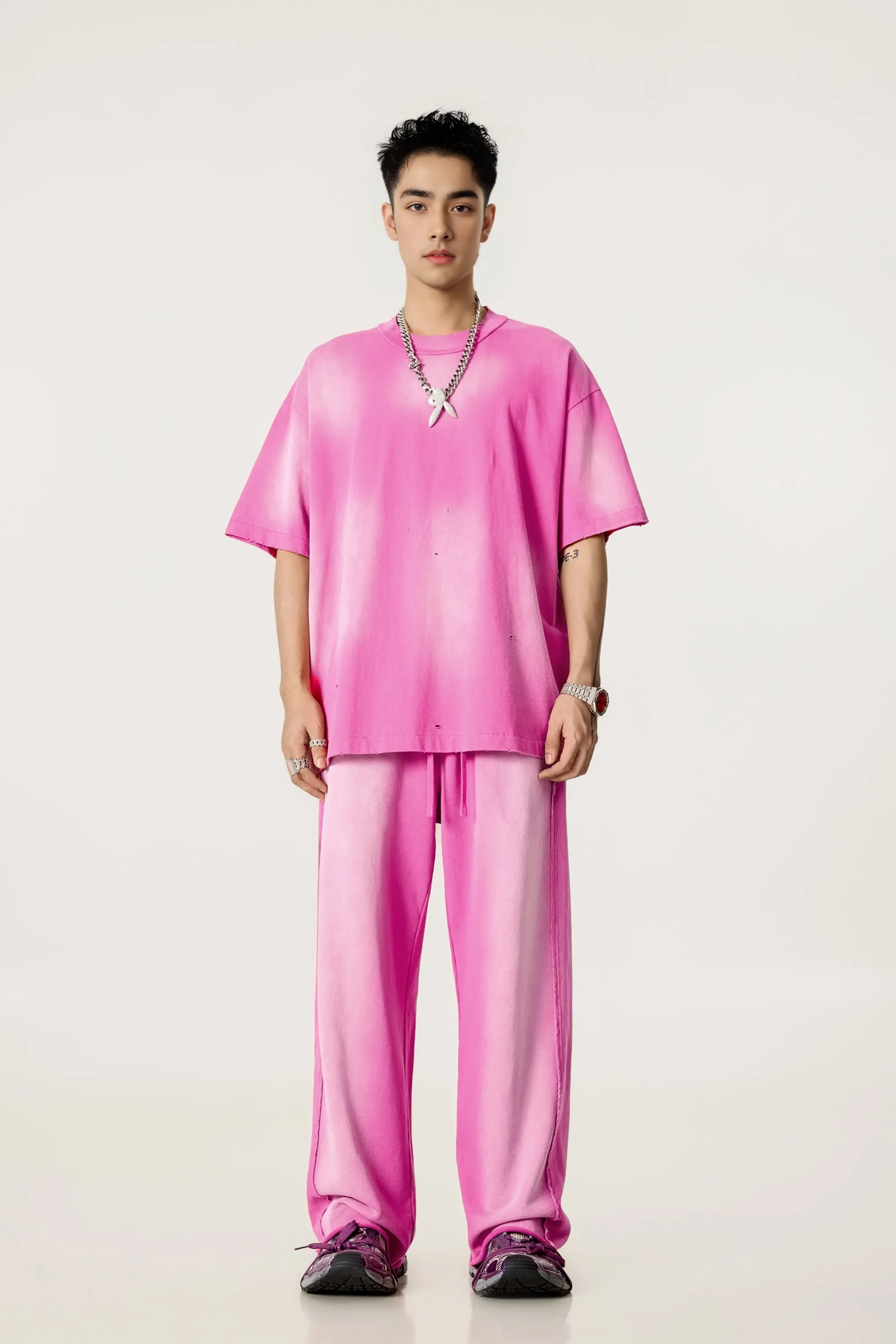 Person wearing a bright pink outfit on a white background