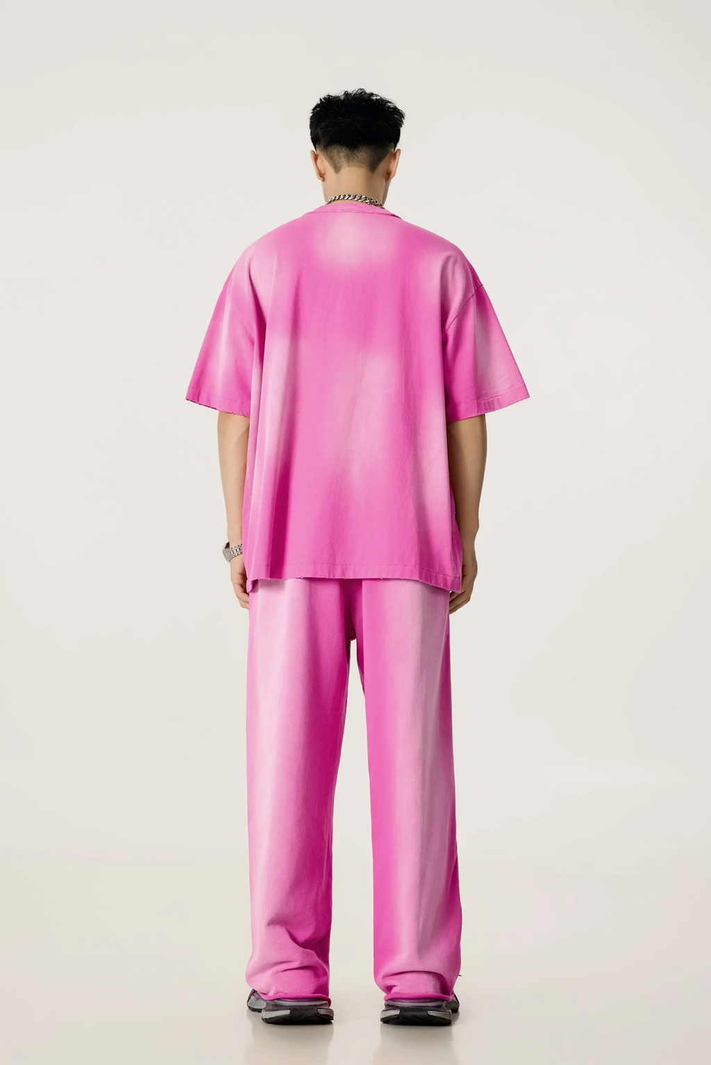Person wearing a pink outfit on a plain background