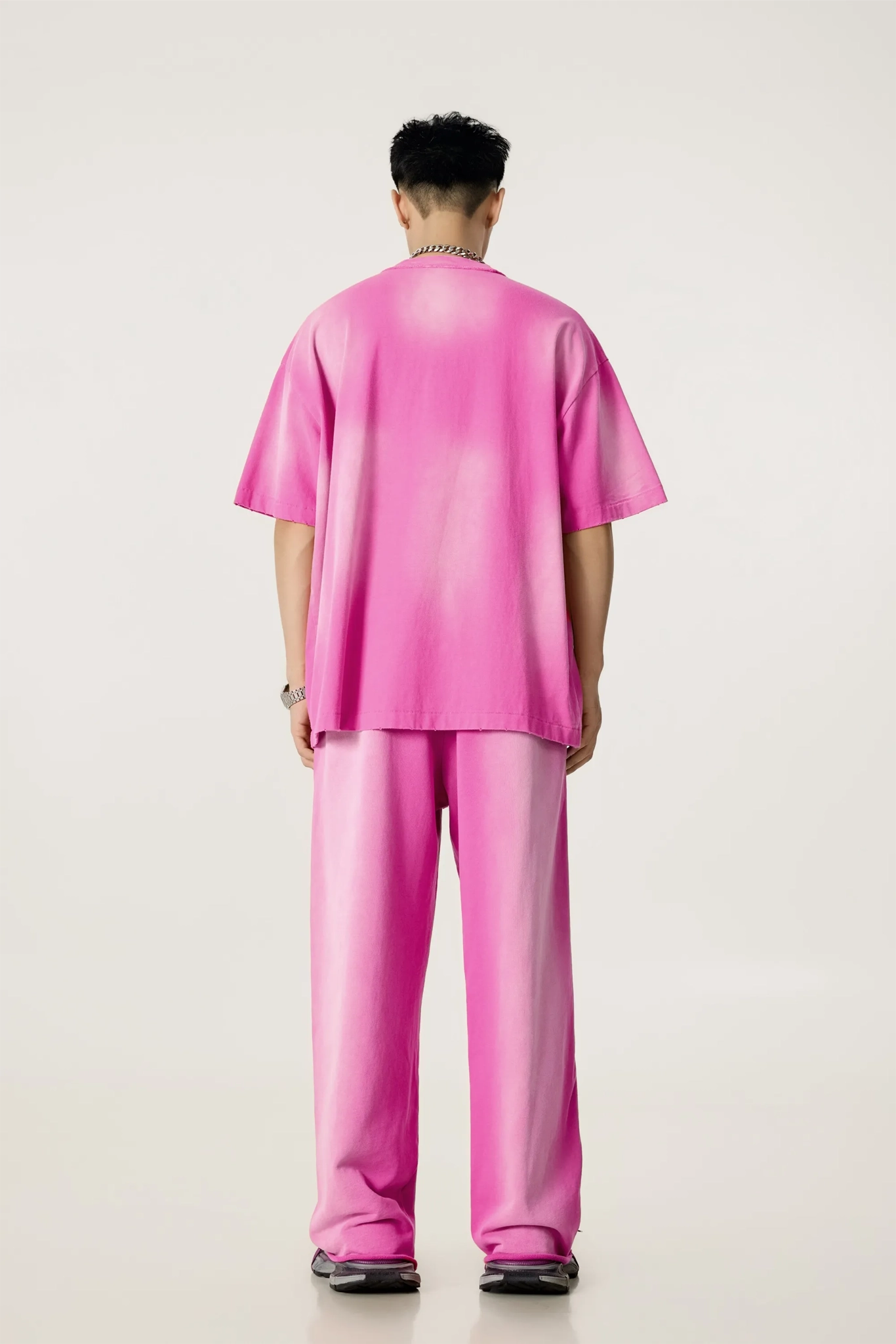 Person wearing a pink outfit on a plain background