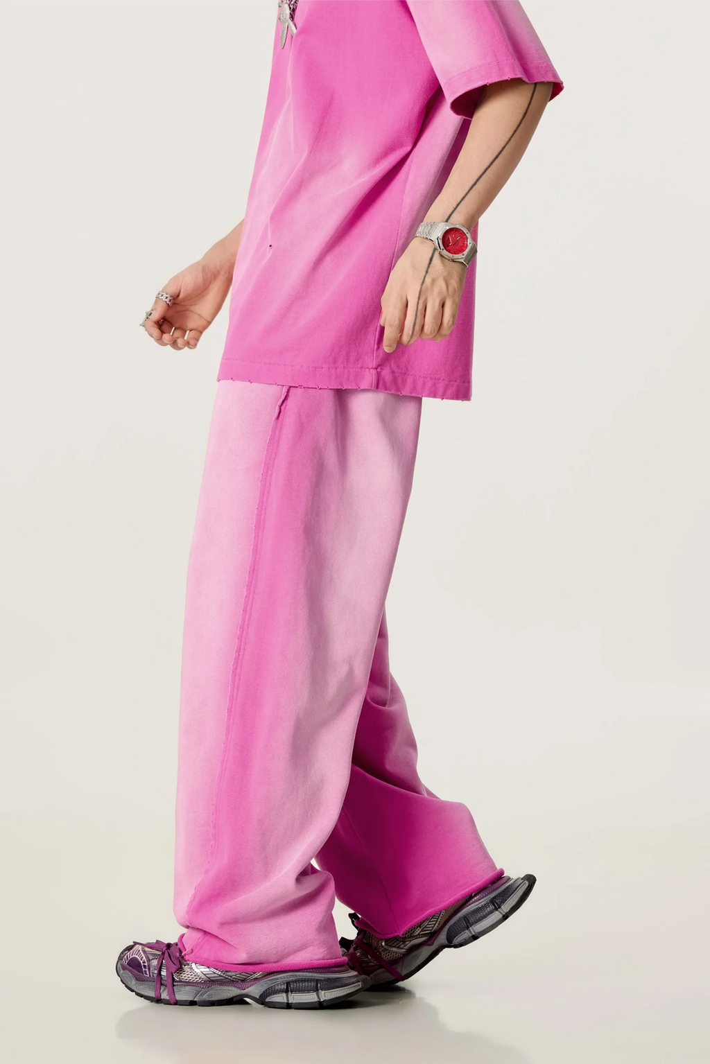 Person wearing a bright pink outfit with a plain background