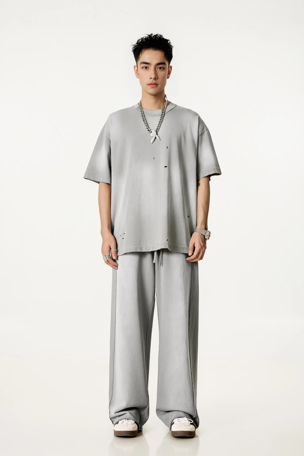 Person wearing a gray outfit on a white background