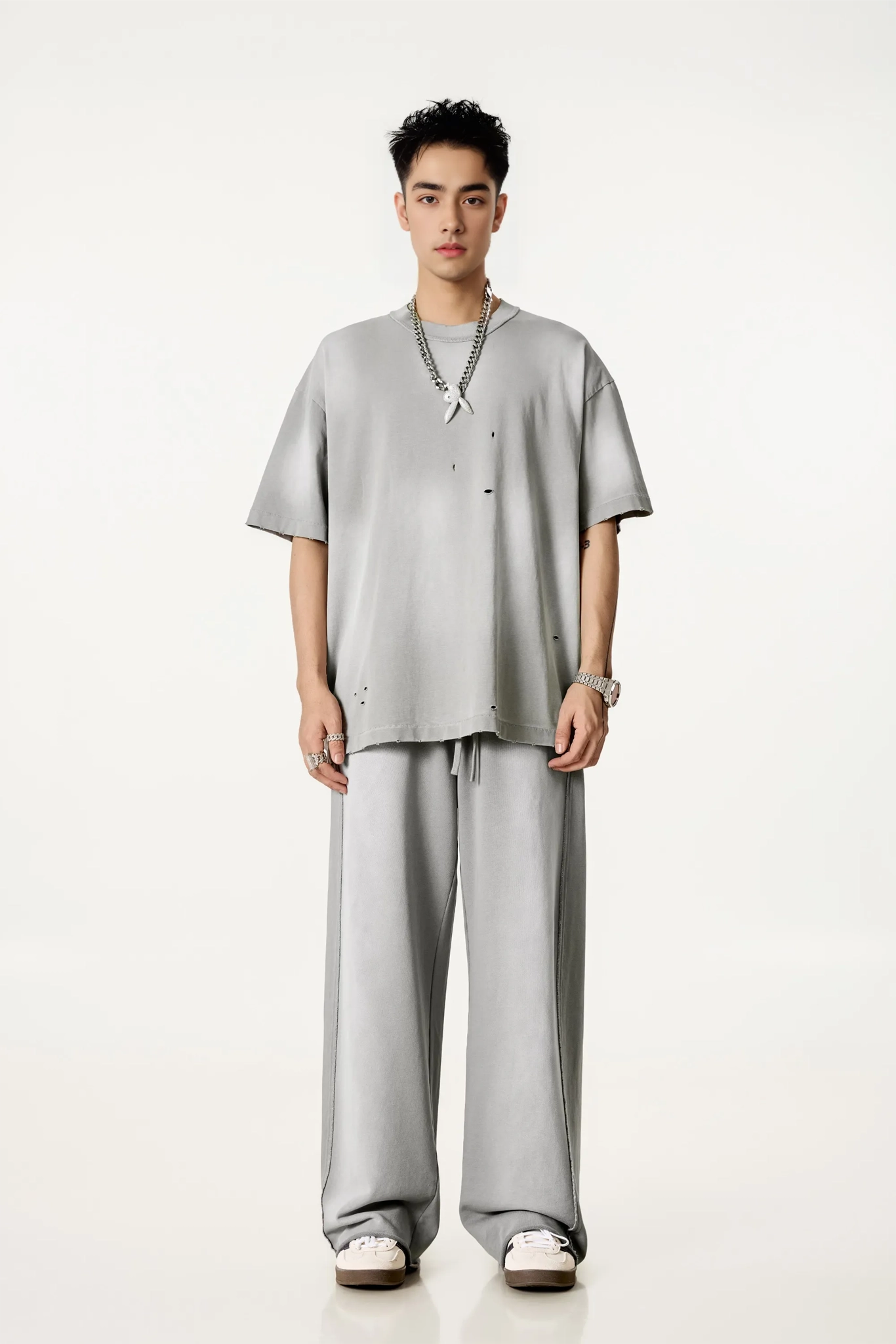 Person wearing a gray outfit on a white background