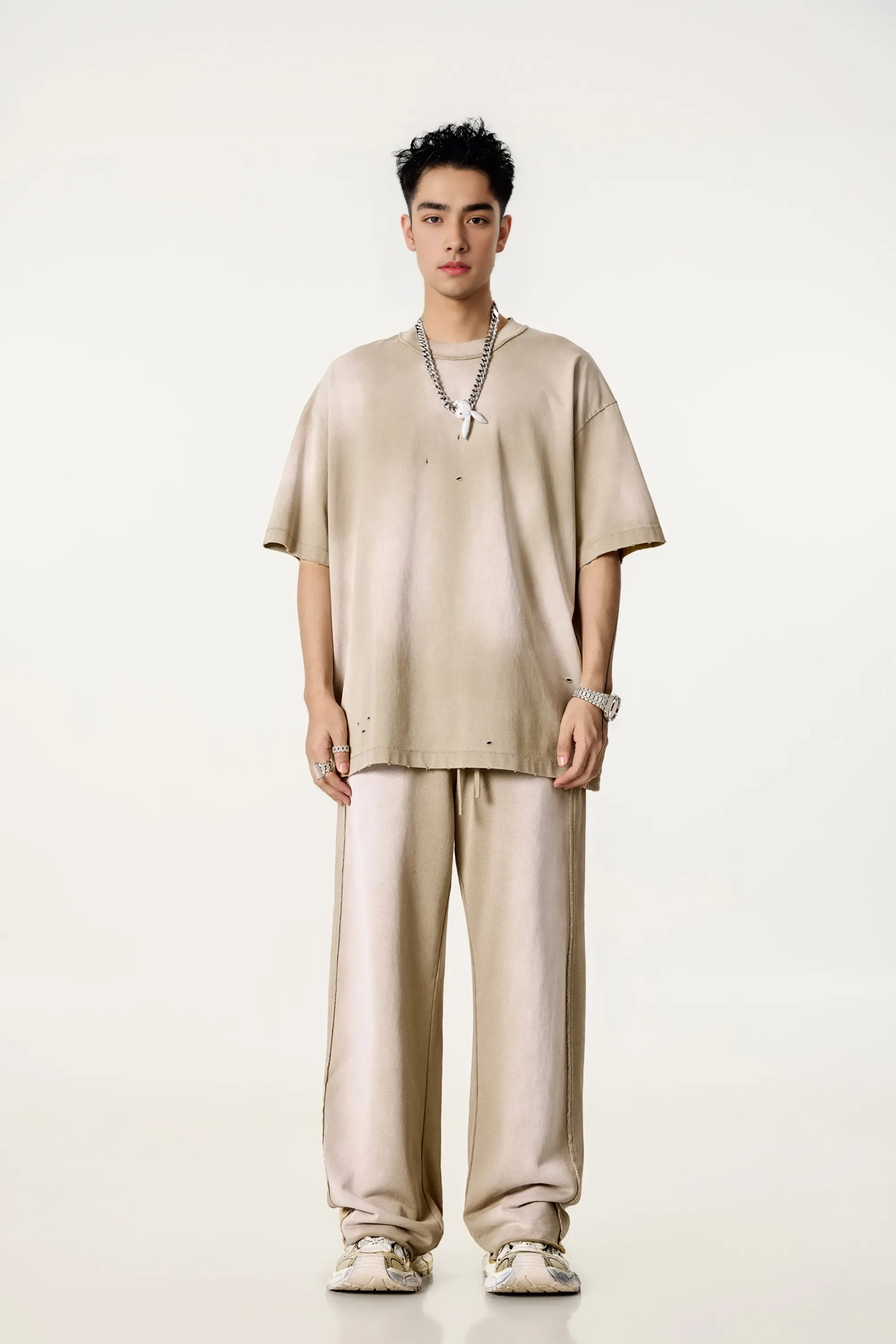 Person wearing a beige outfit on a white background