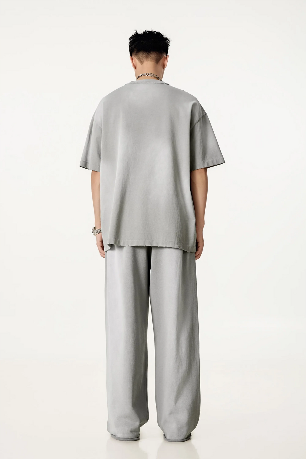 Person wearing a gray outfit on a white background