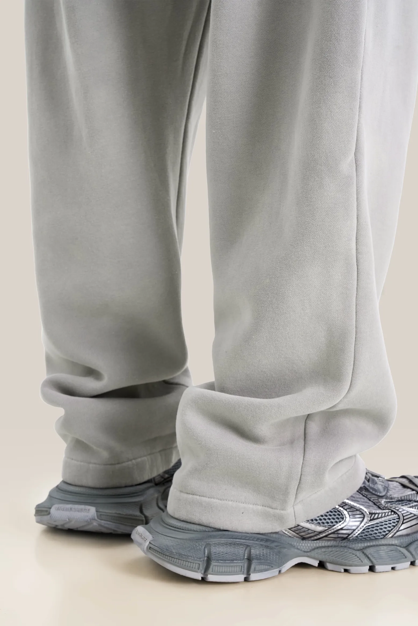Gray sweatpants and sneakers on a light beige background