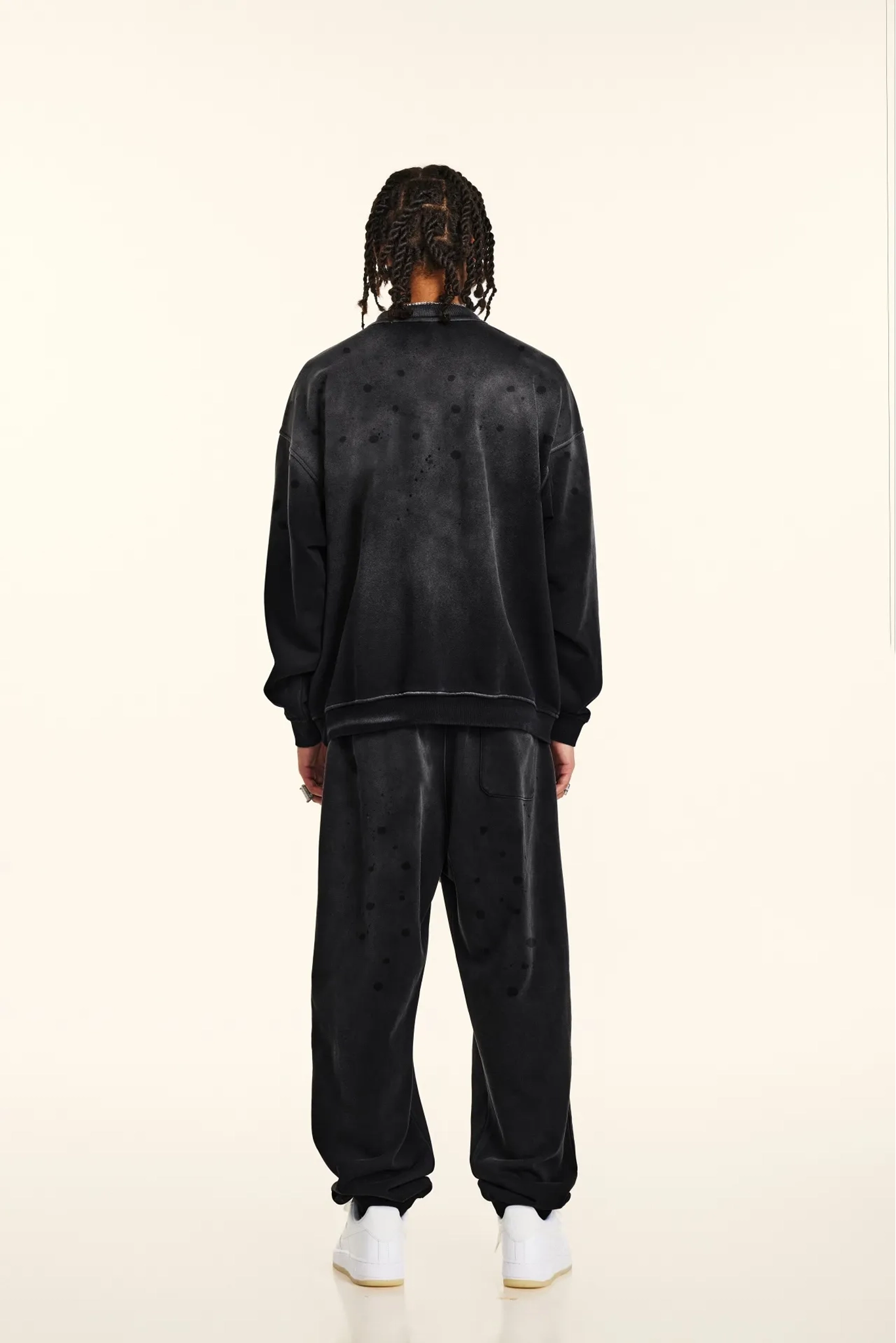 Person wearing a black tracksuit on a white background