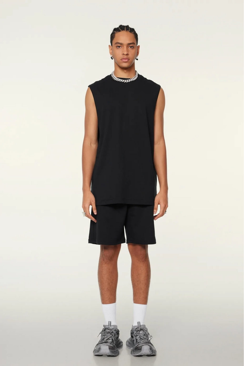 Person wearing a black sleeveless shirt and shorts on a white background