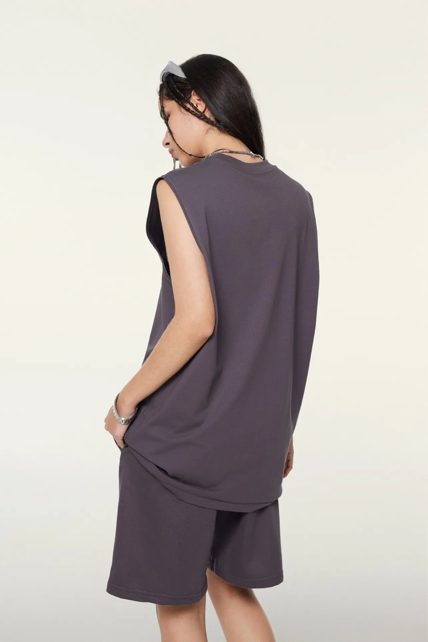 Woman wearing a sleeveless purple dress on a white background