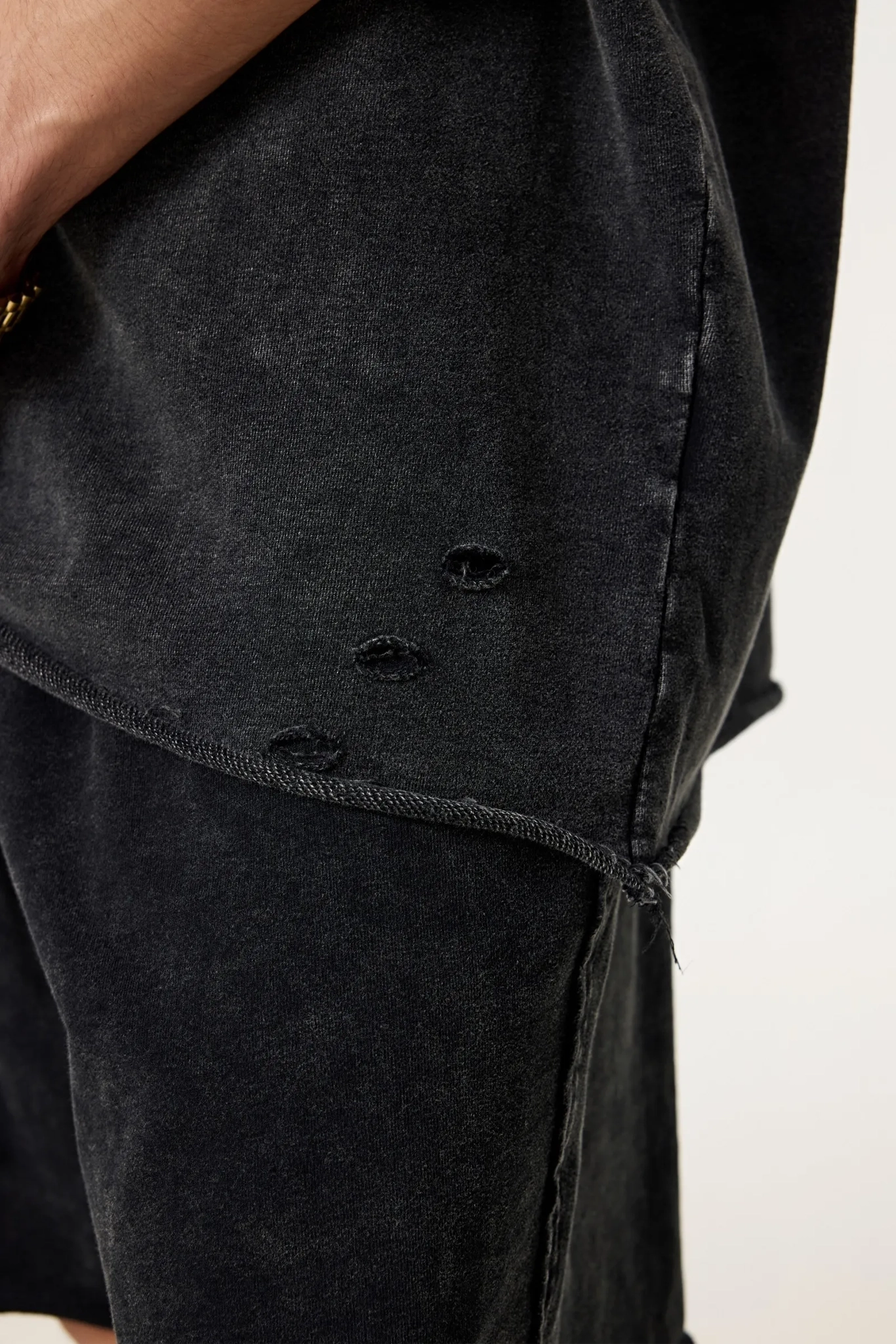 Black distressed denim jacket on a white background