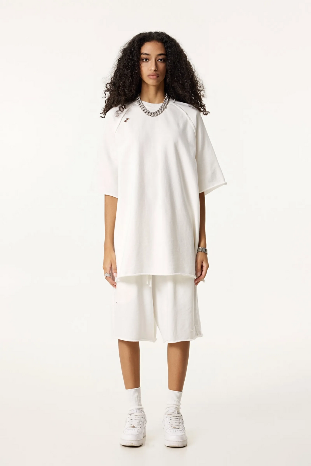 Woman wearing a white dress with a high-low hem on a white background