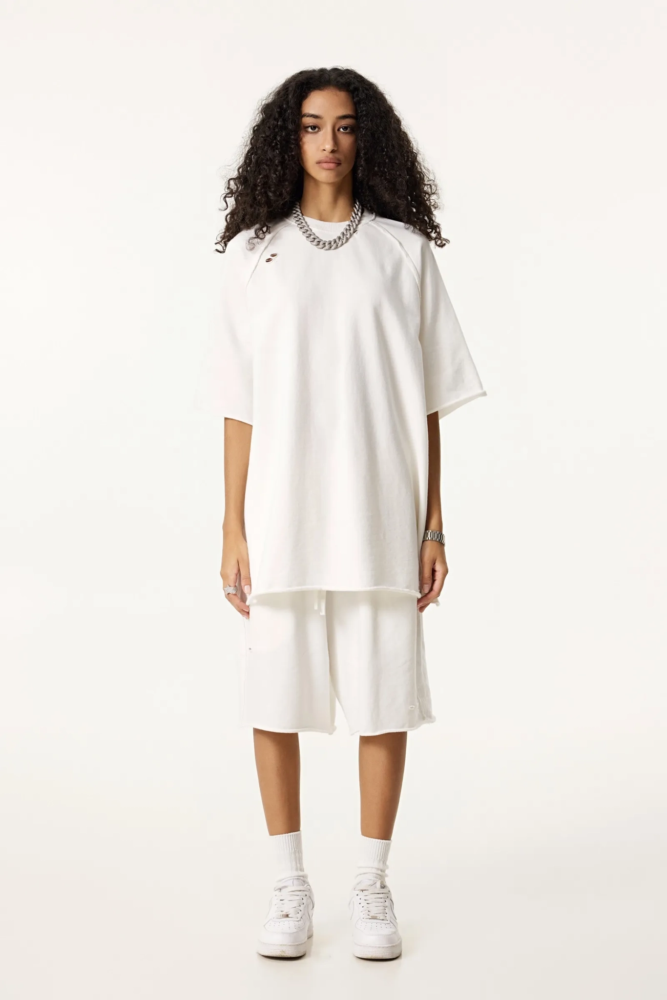 Woman wearing a white dress with a high-low hem on a white background