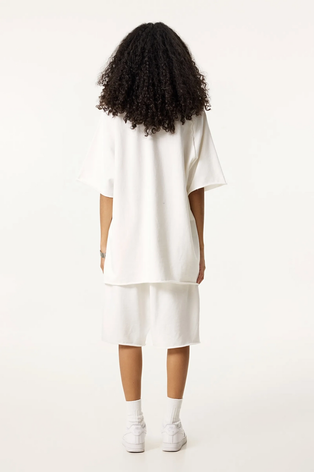 Person wearing a white outfit on a white background