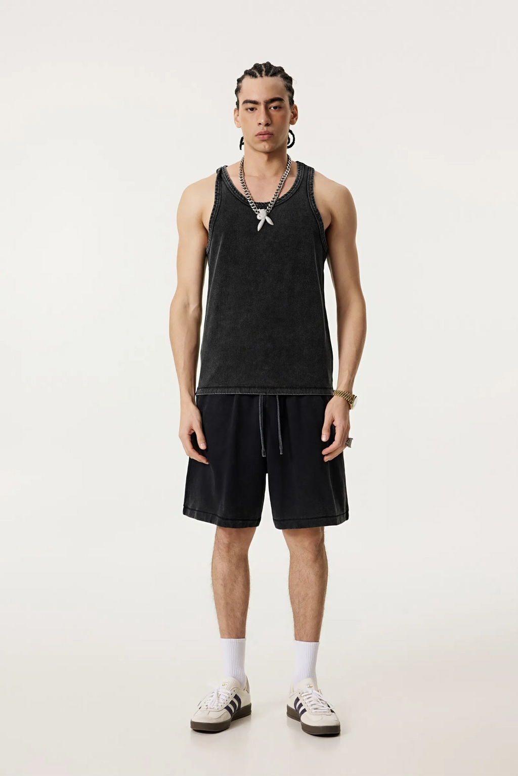 Person wearing a black tank top and shorts on a white background