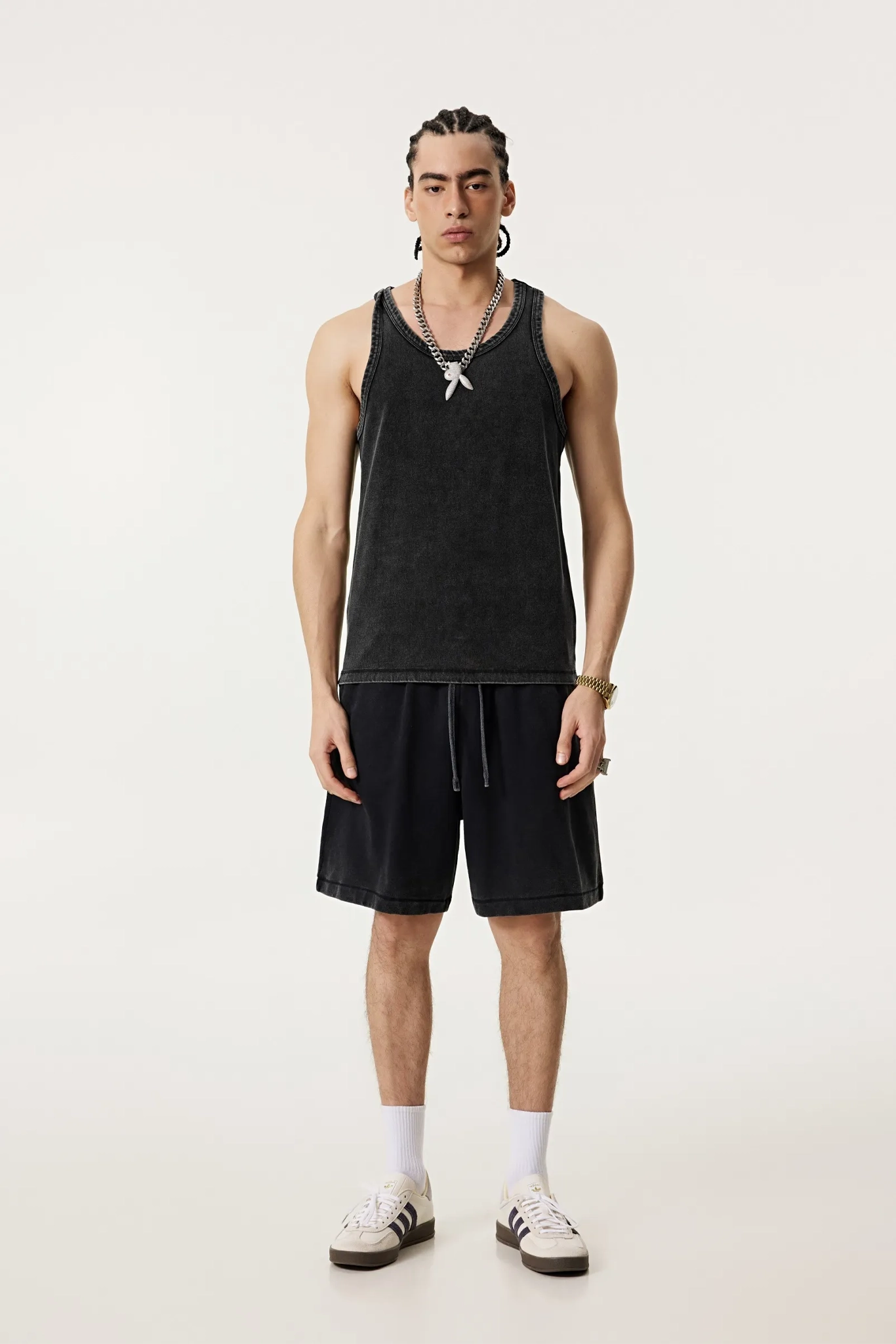 Person wearing a black tank top and shorts on a white background