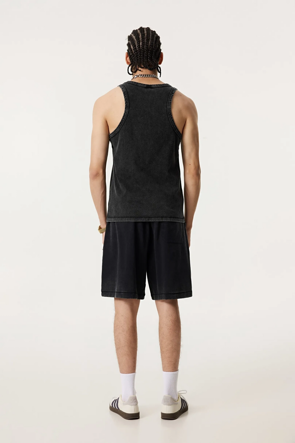 Person wearing a black tank top and shorts on a white background