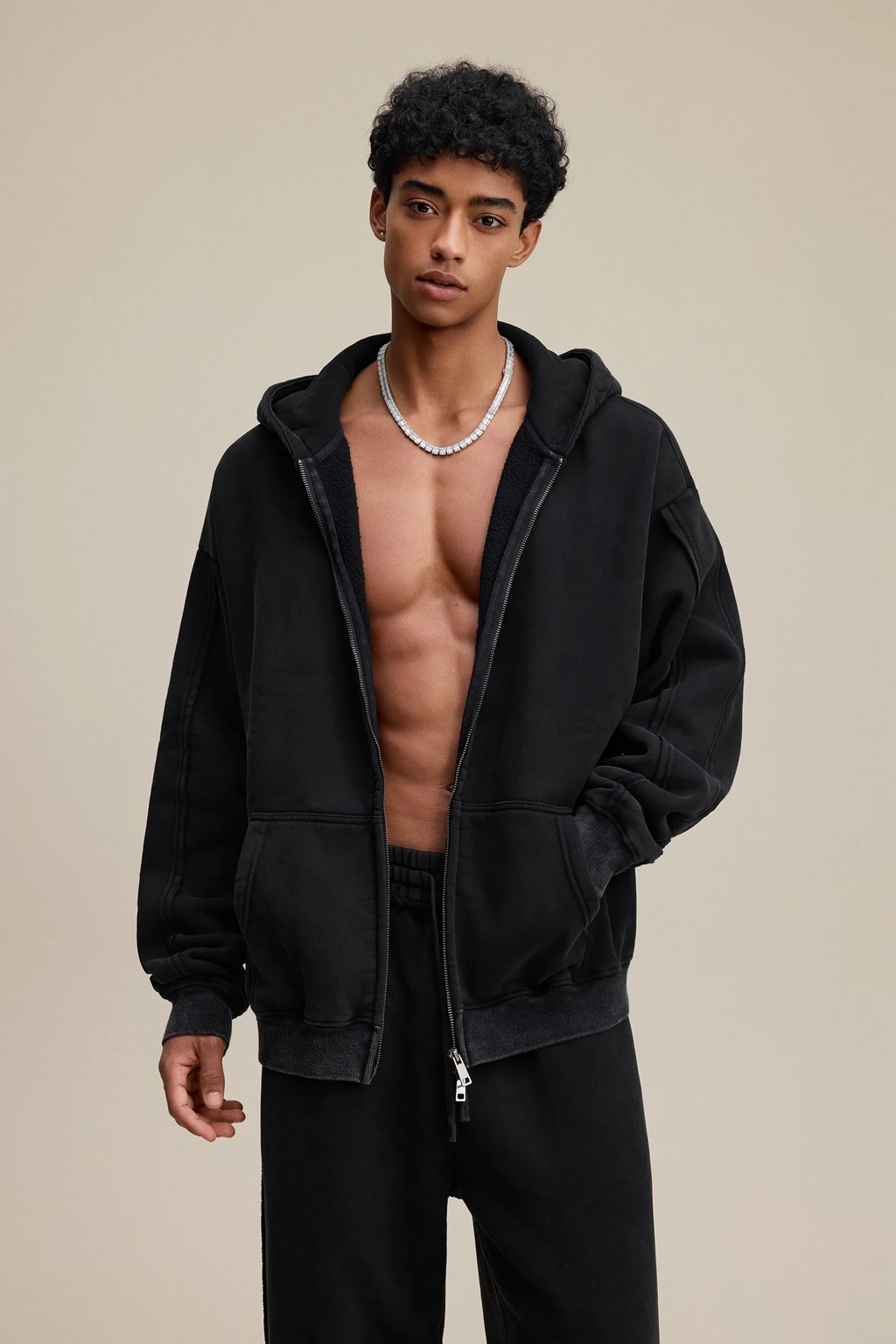 Man wearing a black hoodie on a beige background