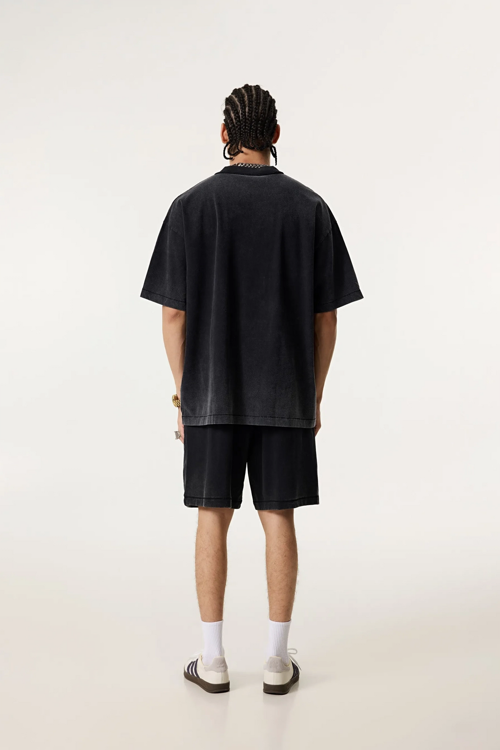 Person wearing a black t-shirt and shorts on a white background