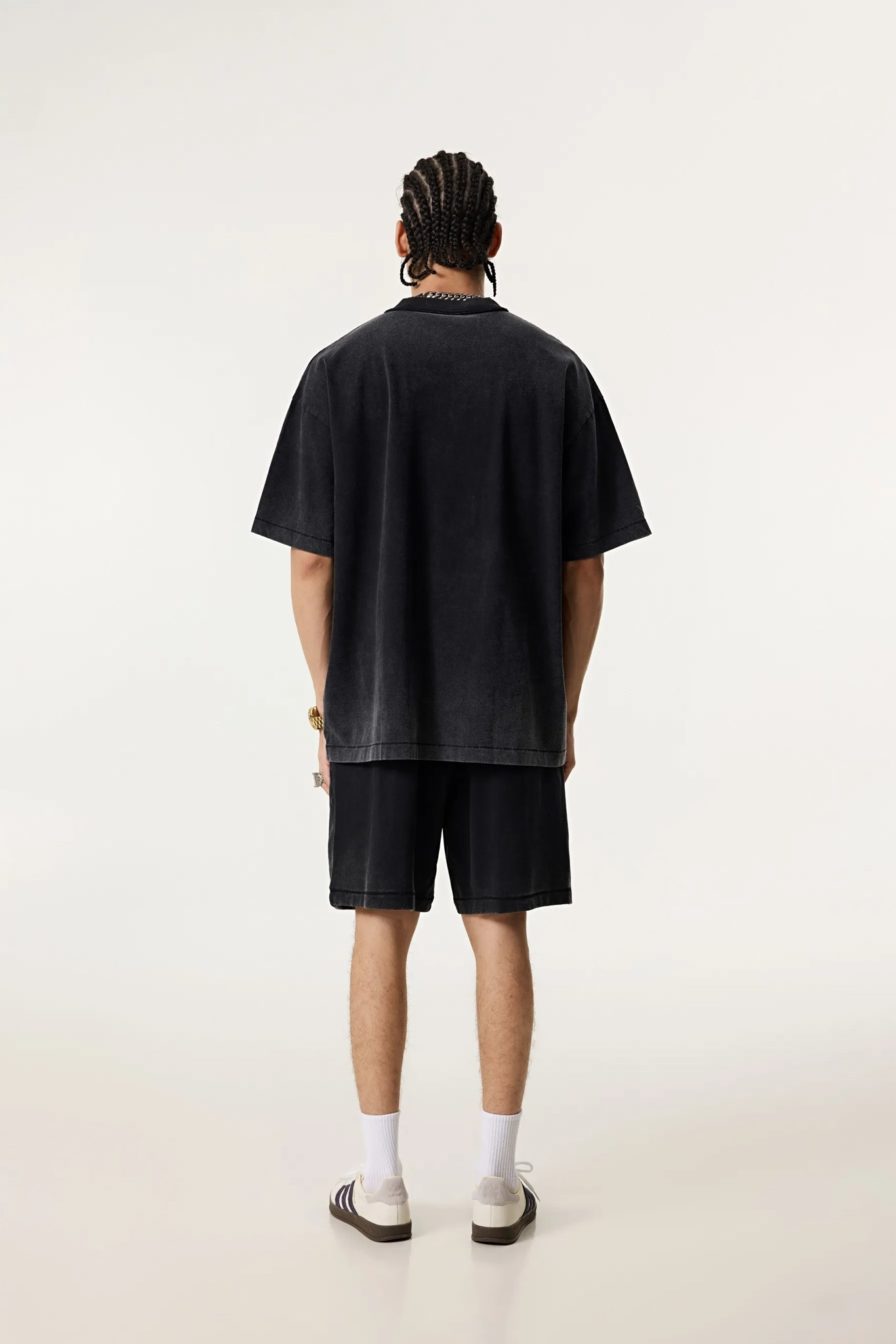 Person wearing a black t-shirt and shorts on a white background