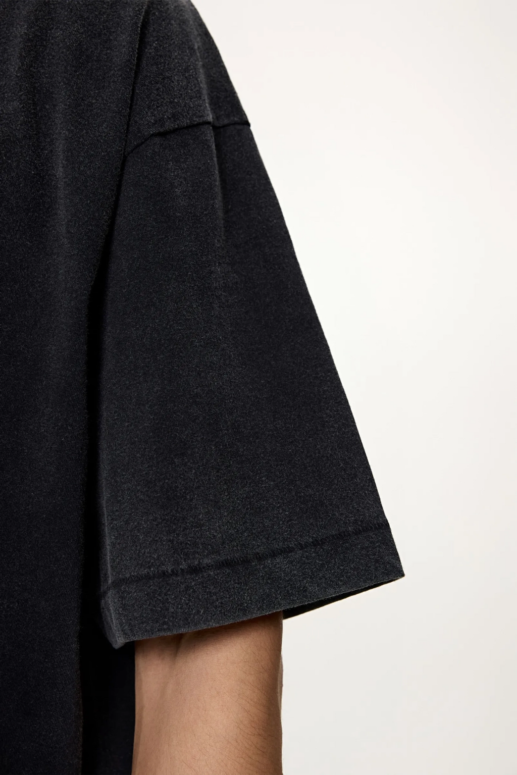 Dark gray sleeve of a garment on a white background