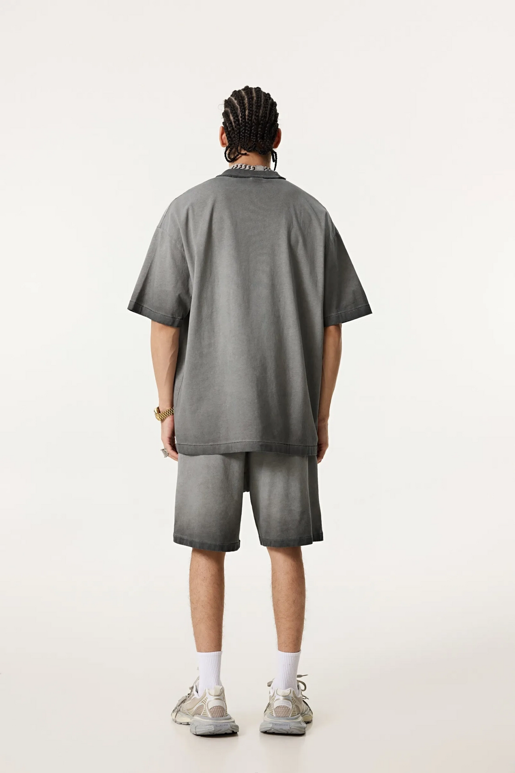 Person wearing a gray t-shirt and shorts set on a white background