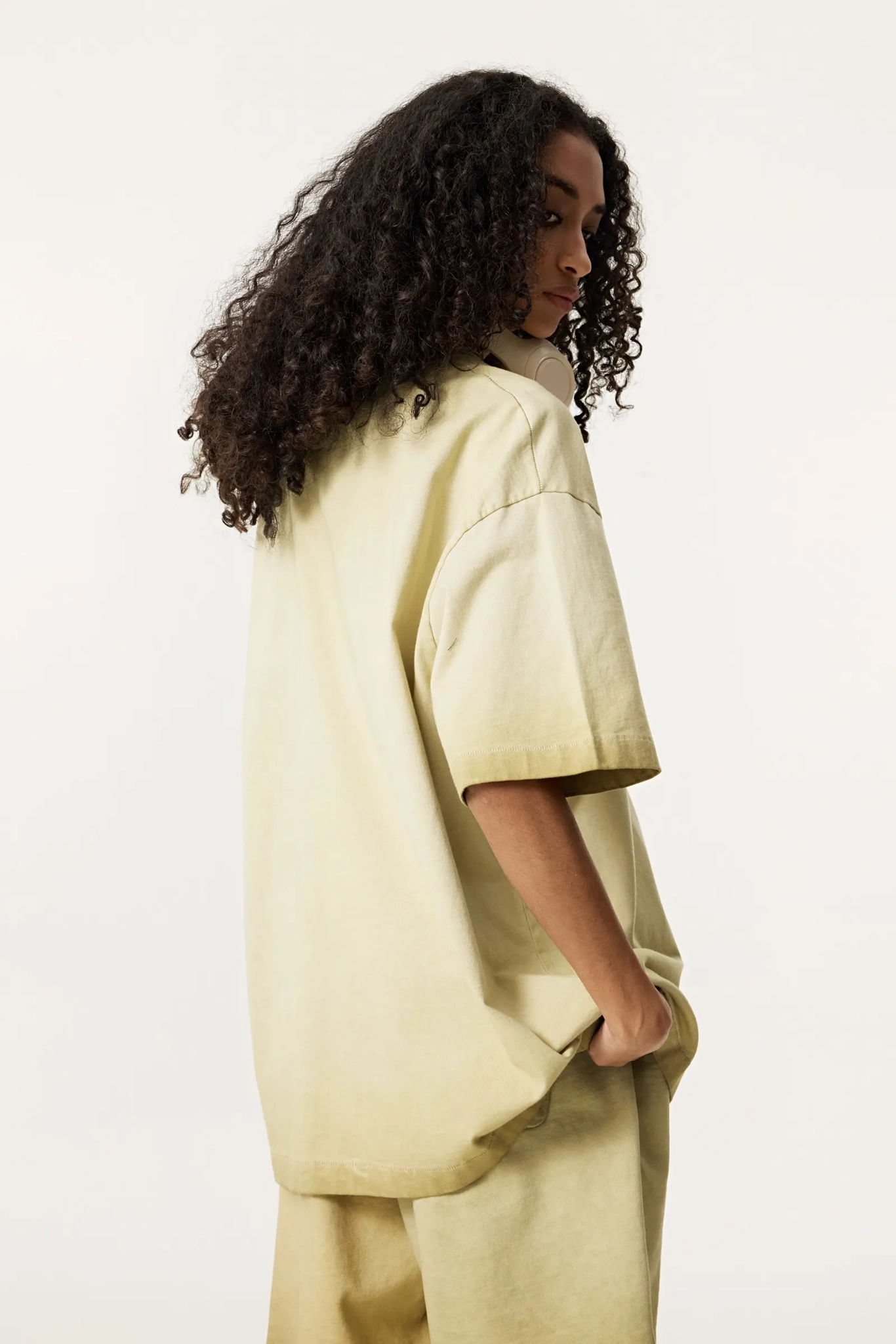 Person wearing a beige outfit on a white background