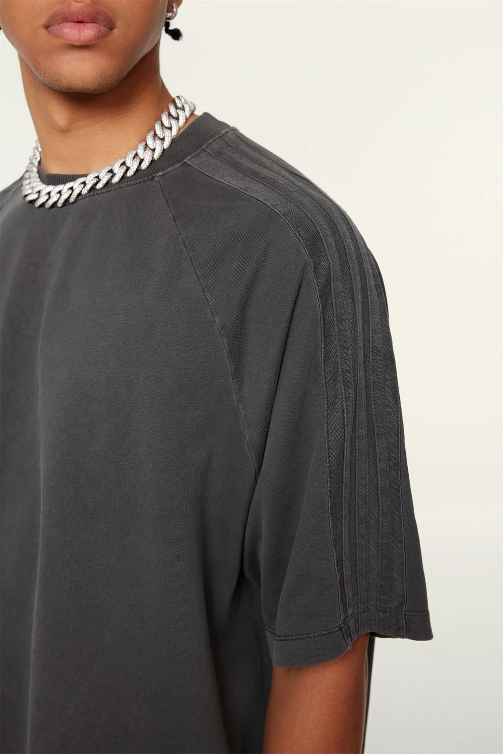 Person wearing a dark gray t-shirt with a white background