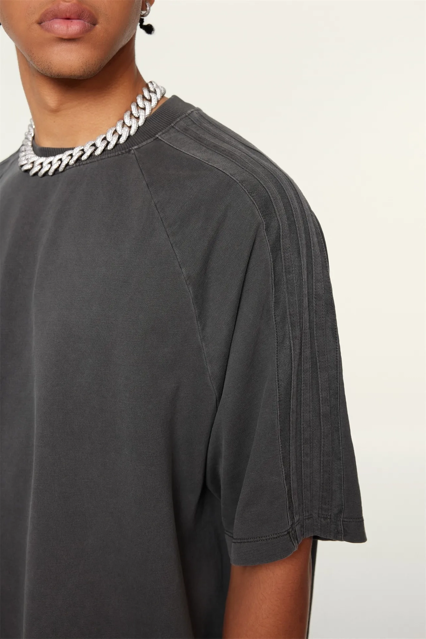 Person wearing a dark gray t-shirt with a white background