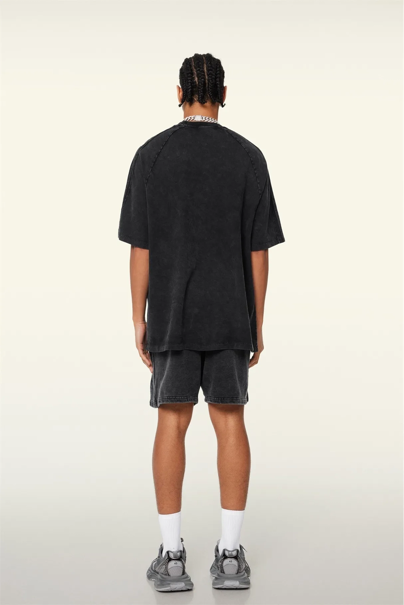 Person wearing a black t-shirt and shorts on a white background