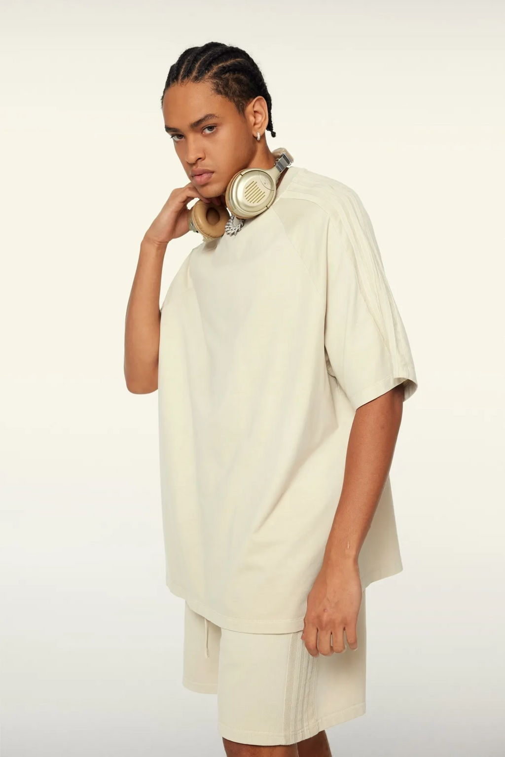 Person wearing a beige outfit with a plain background