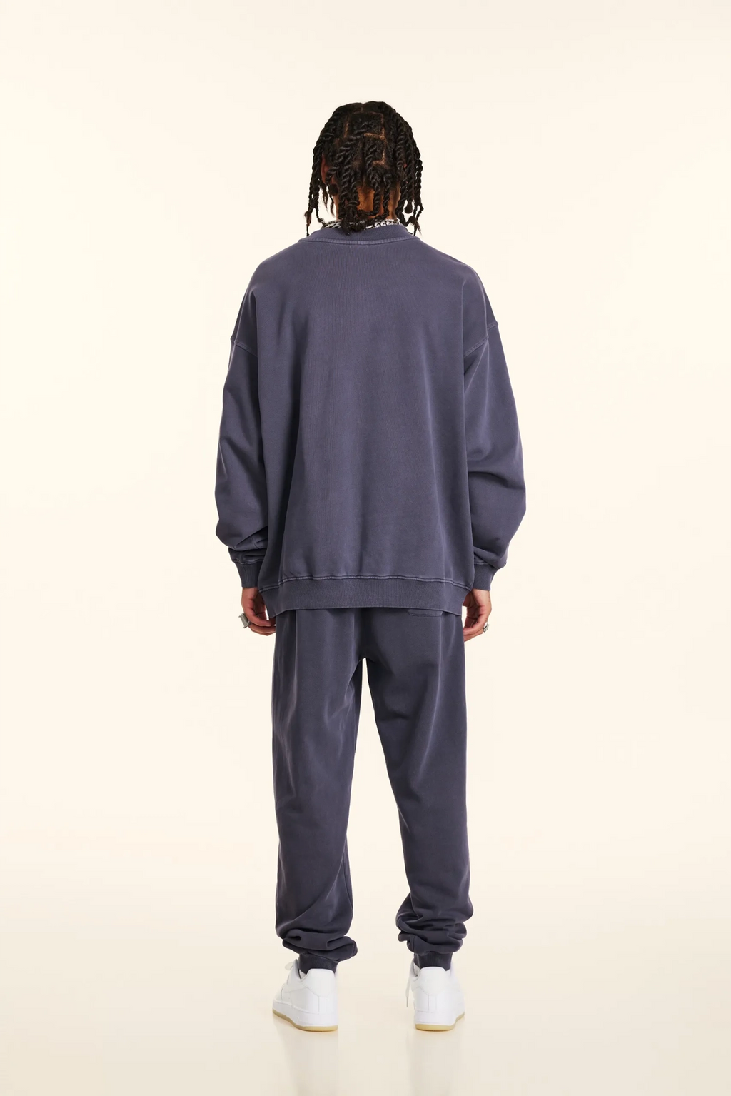 Person wearing a gray tracksuit on a white background