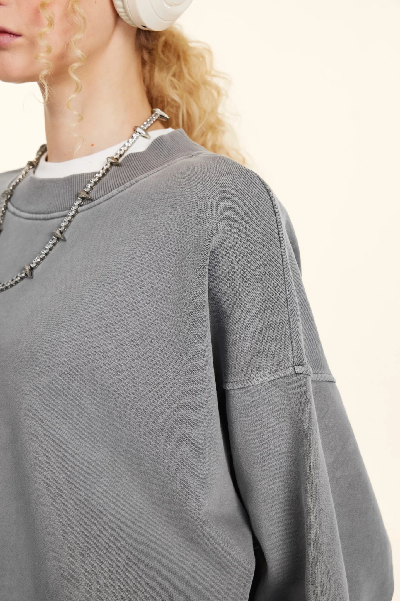 Gray sweatshirt worn by a person with a neutral background