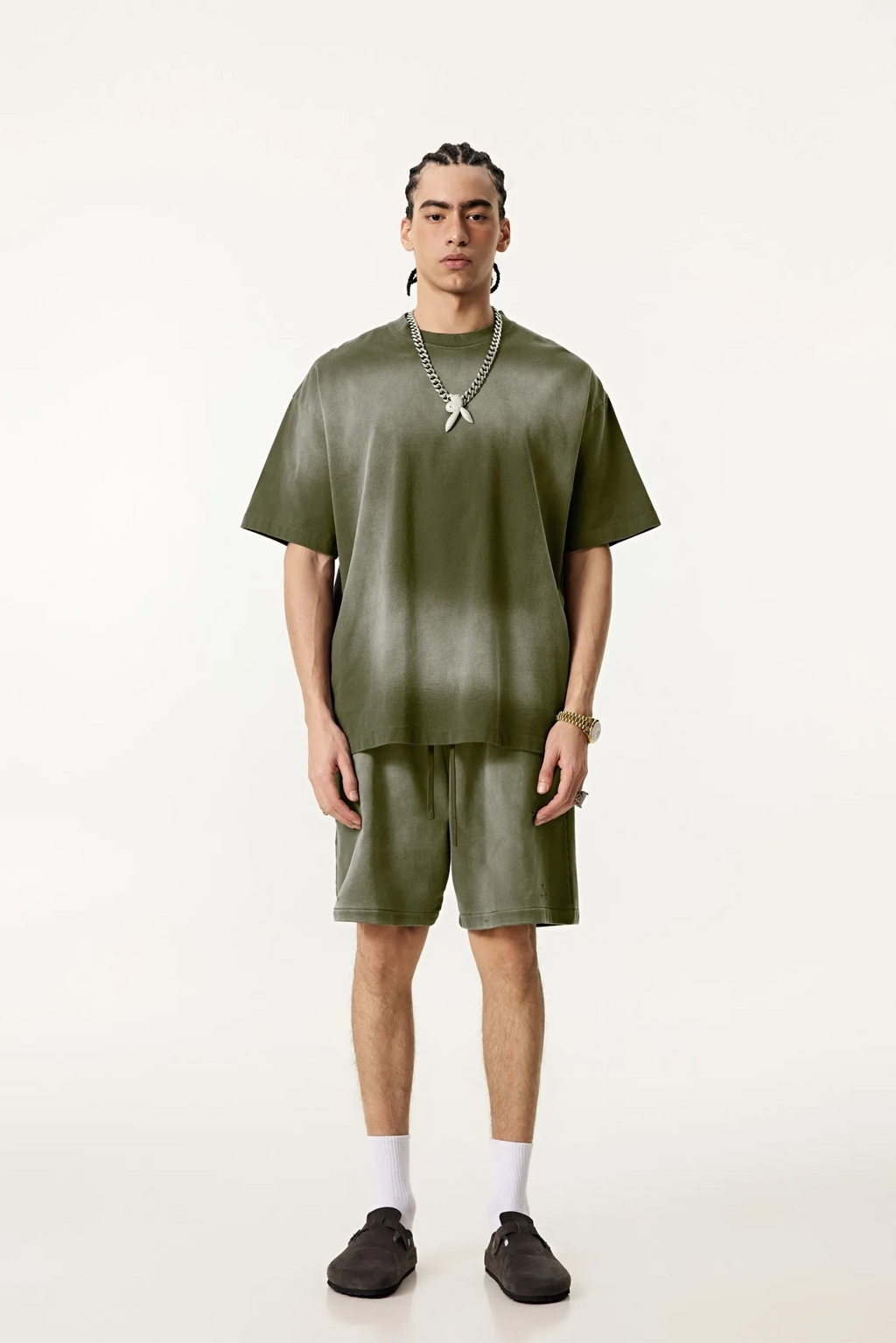 Person wearing a green outfit with a plain background