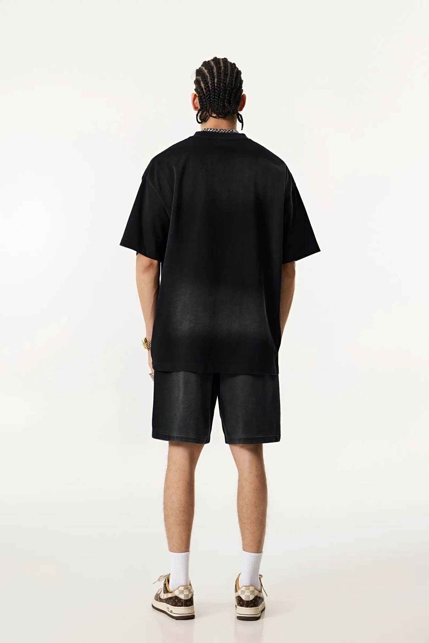 Person wearing a black t-shirt and shorts set on a white background