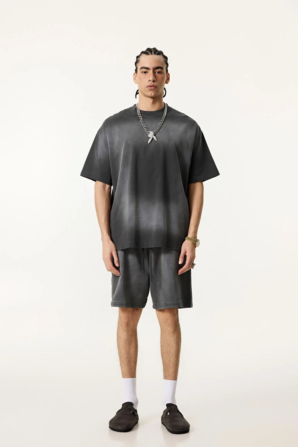 Person wearing a gray outfit with a plain background