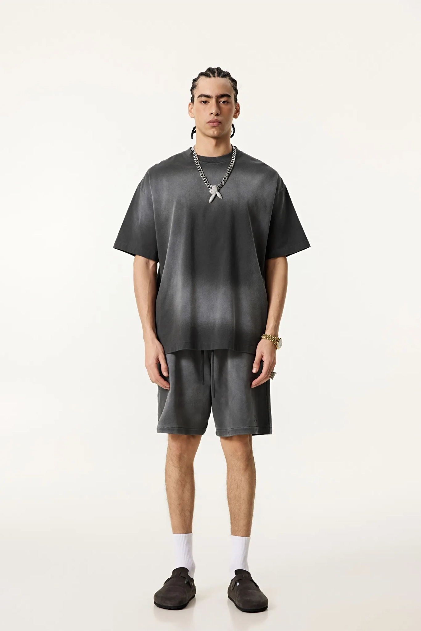 Person wearing a gray outfit with a plain background